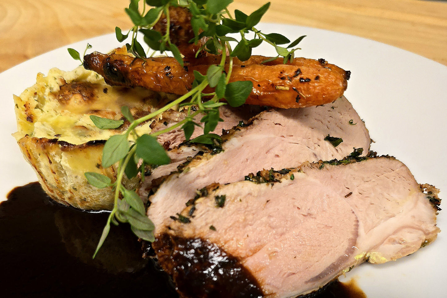 Örtbakad fläskfilé med potatisbakelse, örtsmör & black garlic sås